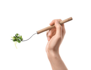 Woman holding fork with fresh micro green on white background