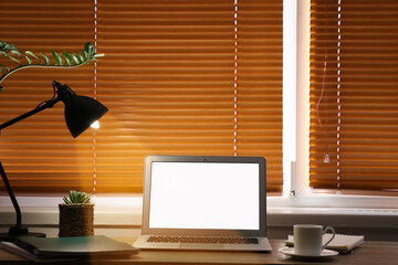 Modern workplace with laptop near window