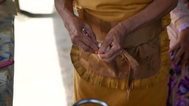 An Indonesian old woman is preparing "Gado Gado" for customers. Gado gado is a Traditional food from Indonesia