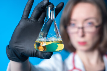 Laboratory technician with test tube. Laboratory technician's face is blurred. Girl employee of...