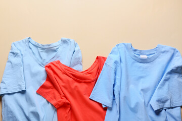 Stylish t-shirts on color background, closeup