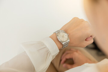 fashionable wearing stylish looking at luxury watch on hand check the time at workplace.concept for...