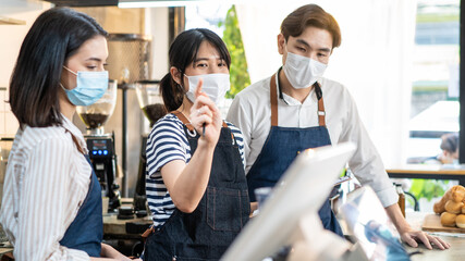 Asian coffeehouse worker people meeting and discuss work plan in store