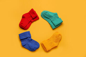 Frame made of baby socks on color background