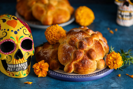 Bread of the dead and painted skull on color background. Celebration of Mexico's Day of the Dead (El Dia de Muertos)