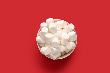 Bowl with tasty marshmallows on color background