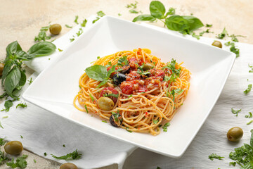Plate with tasty Pasta Puttanesca on light background
