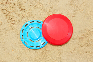 Colorful frisbee disks on sand