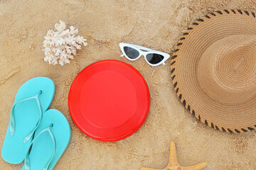 Composition with frisbee disk and beach accessories on sand