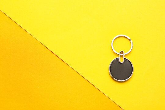 Stylish keychain on color background