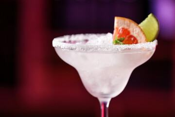 Glass of tasty grapefruit margarita in bar, closeup