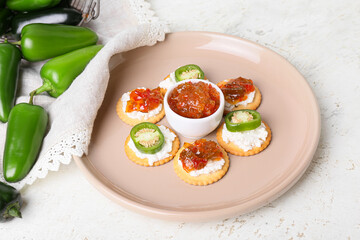 Delicious crackers with cottage cheese and jalapeno pepper jam in plate on light background