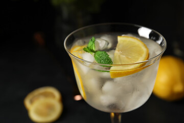 Glass of cold gin and tonic on dark background, closeup