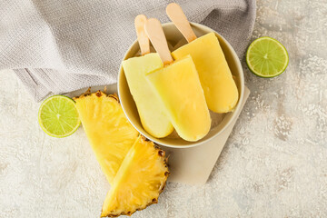 Bowl with tasty pineapple popsicles on light background