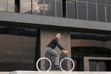 Businessman going to work by bicycle on city street