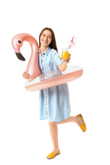 Young woman with cocktail and inflatable ring on white background