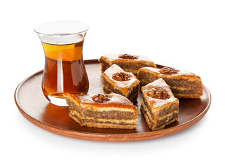 Plate with tasty baklava and glass of Turkish tea on white background