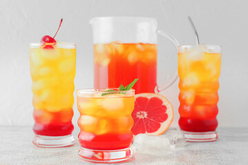 Glasses of tasty Tequila Sunrise cocktail on light background