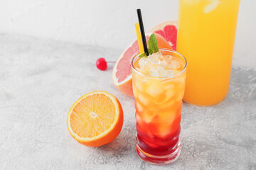 Glass of tasty Tequila Sunrise cocktail on light background