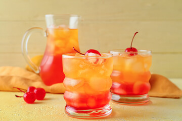 Glasses of tasty Tequila Sunrise cocktail on color background