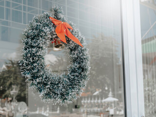 Christmas background. Christmas wreath ornate with red ribbon and a golden bell hanging on a clean...