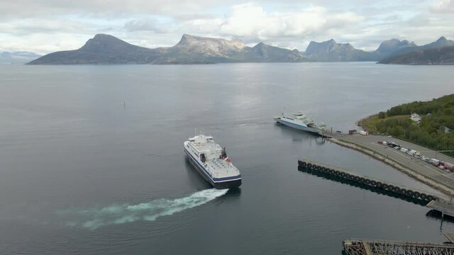Aerial shot tracking a ferry boat docking in the fiords of Norway