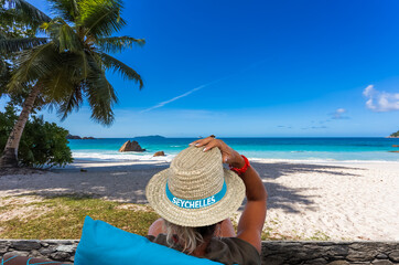 Femme au chapeau sur plage d’Anse Lazio, Praslin, Seychelles 