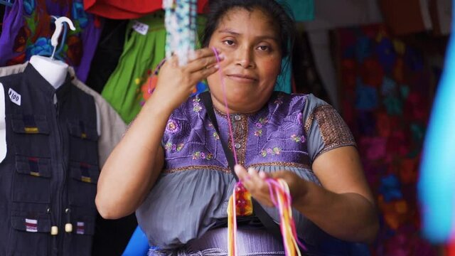 Young Latina sitting looking at the camera while working in a clothing store in Chiapas, Mexico