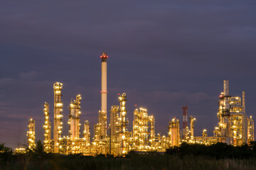 Lights in oil refinery industry factory power petroleum station show under working at night time with dark sky.