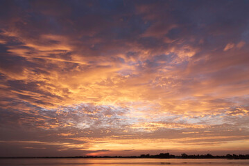 Fototapeta premium Scenic view dramatic beautiful sunset sky. Natural Sunset Sunrise on meadow silhouette shadow dark land. Vibrant dramatic sky on sunset, dawn, sunrise in Countryside. Landscape Colorful Sky At Sunset