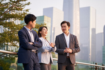 asian business people chatting outdoors