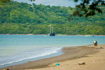 Fototapeta na wymiar Paisaje de una playa con un embarcación de fondo 