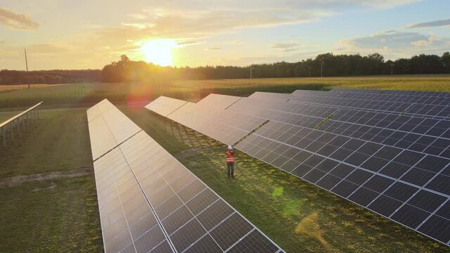 Solar engineer planning, designing and implementing the layout of solar farms during golden hour. Aerial.