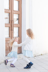 Happy Children Holding Hands. Two Little Girls Enjoying Life Whirl Outdoor Under Sunlight. Happy childhood of two sisters. Walking by the old mansion.