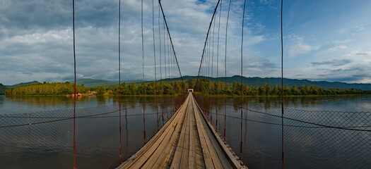 Fototapeta premium Russia. Chita region. A suspension road bridge over the Chikoy River, connecting the district center with the village of Krasny Priisk.