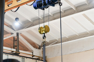 Chains for lifting loads on a telpher crane in a workshop at a factory.