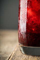 Blackberry cocktail with crushed ice on the rustic wooden background. Selective focus. Shallow depth of field.
