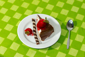 pastel de chocolate con fresas 3 leches  rebanada y cuchara mantel verde