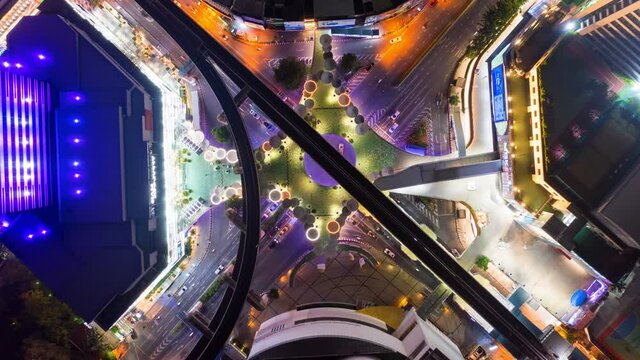 Time lapse of aerial view of Siam Bangkok Art and Skywalk aerial view in MBK Culture Center intersection or junction with cars traffic skyscraper buildings. Bangkok City in downtown at night, Thailand