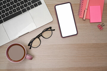 Mock up smart phone with blank screen and laptop computer on wooden table.