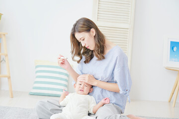 Obraz na płótnie Canvas 赤ちゃんの体温を測る母親