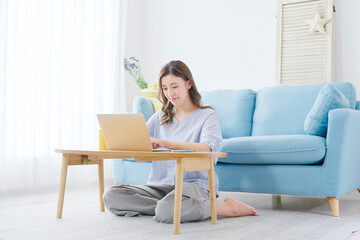 部屋でパソコンを使う女性