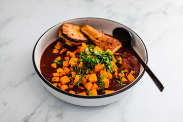 vegan butter chicken curry with pumpkin swede and parsnip topped with fresh homegrown cioriander, healthy plant-based food