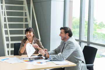 Two analysts discussing in front of laptop at office.