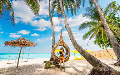 Beautiful nature view scenic landscape tropical palm beach with traveler woman on straw nests,...