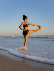 Yoga practice on the beach. Utthita Hasta Padangusthasana, Extended Hand-to-Big-Toe Pose. Standing balancing asana. Fit body. Healthy lifestyle. Support immune. Seminyak beach, Bali