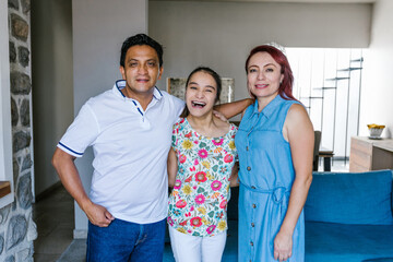 Latin parents and teenage daughter with cerebral palsy in living room at home in Mexico City in...