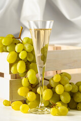Glass of white wine and grape cluster.