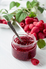 Jar of raspberry jam and fresh berries.