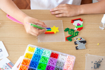 Handmade by children's hands, handmade aquamarine mosaic on the table during assembly, selective focus.